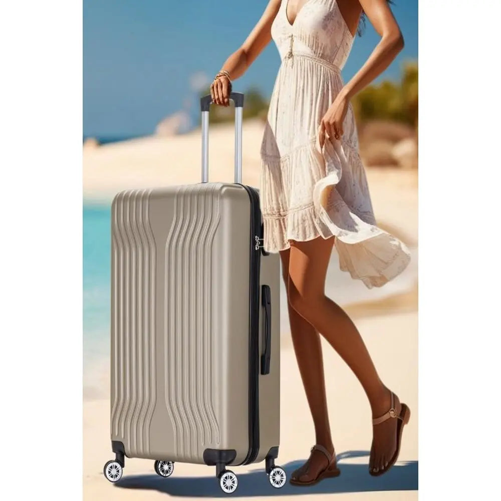 Woman in a light dress holding a beige suitcase on a beach.